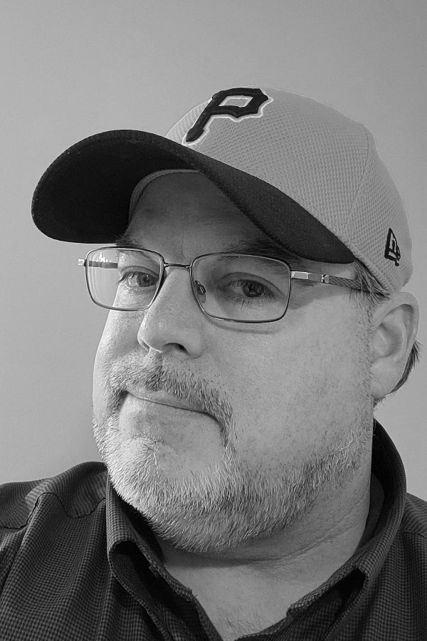 Man wearing a cap with a logo on a plain background