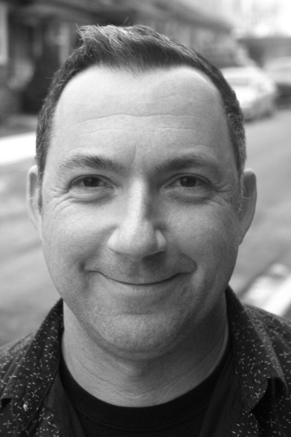 Black and white photo of a person outdoors with blurred background