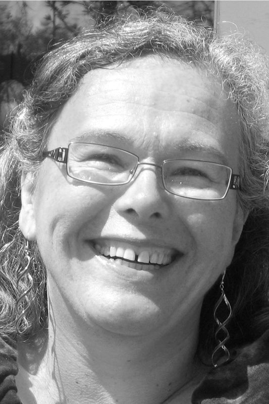 Black and white photo of a person with glasses and earrings