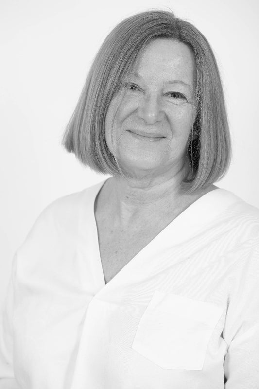 Black and white portrait of a woman with short hair wearing a light-colored top.