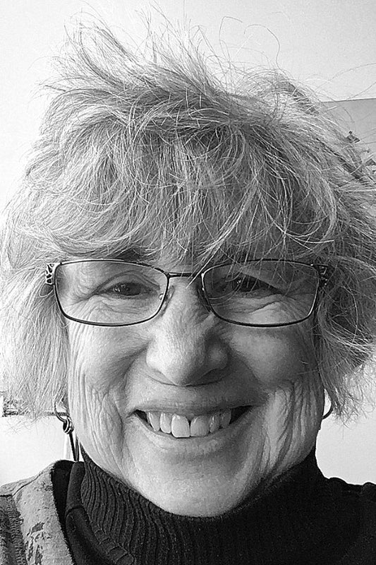 Black and white photo of a person with glasses and a smile