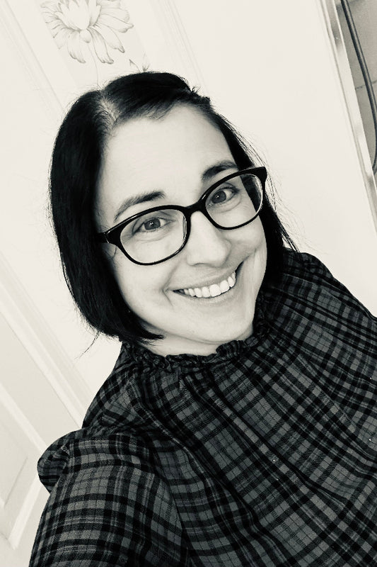 Black and white photo of a person wearing glasses and a plaid shirt.