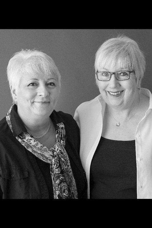 Two women standing side by side against a plain background