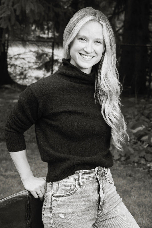 Photo of Bailey Kennedy, woman with long blond hair, wearing a black sweater and jeans.