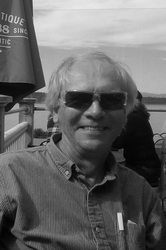 Black and white photo of a man wearing sunglasses with a blurred background