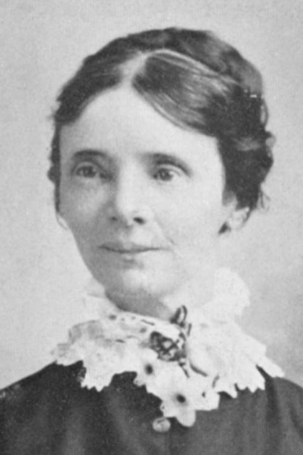Black and white portrait of a woman with a lace collar and hair bun.
