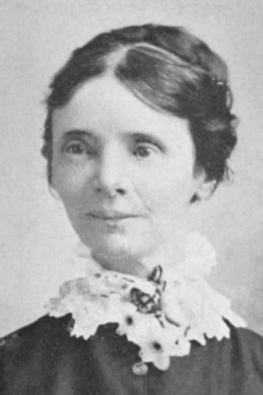 Black and white portrait of a woman with a lace collar and hair bun.