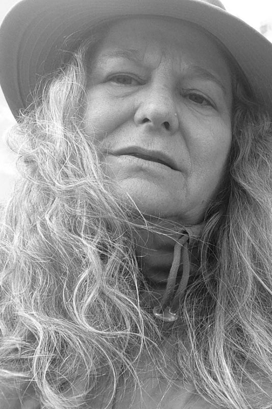 Black and white photo of a person with long hair and a hat