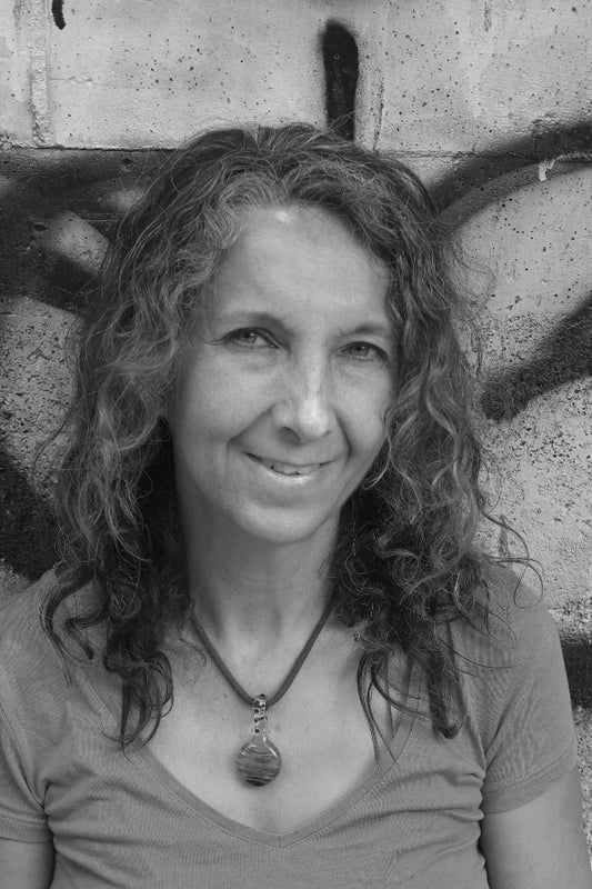 Black and white portrait of a woman with wavy hair against a textured wall.
