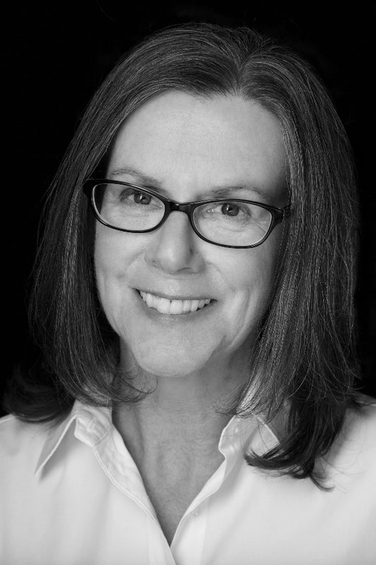 Black and white portrait of a woman wearing glasses and a white shirt.