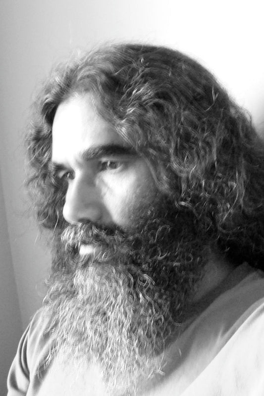 Black and white portrait of a person with a long beard and hair.