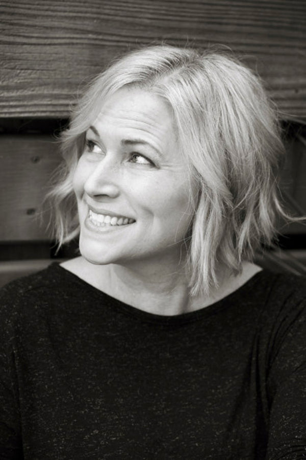 Black and white photo of a woman with short blonde hair smiling.