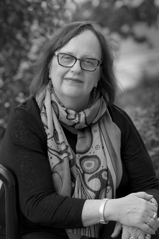 Black and white photo of a woman wearing glasses and a patterned scarf.