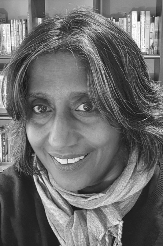 Black and white photo of a woman with a scarf in front of a bookshelf