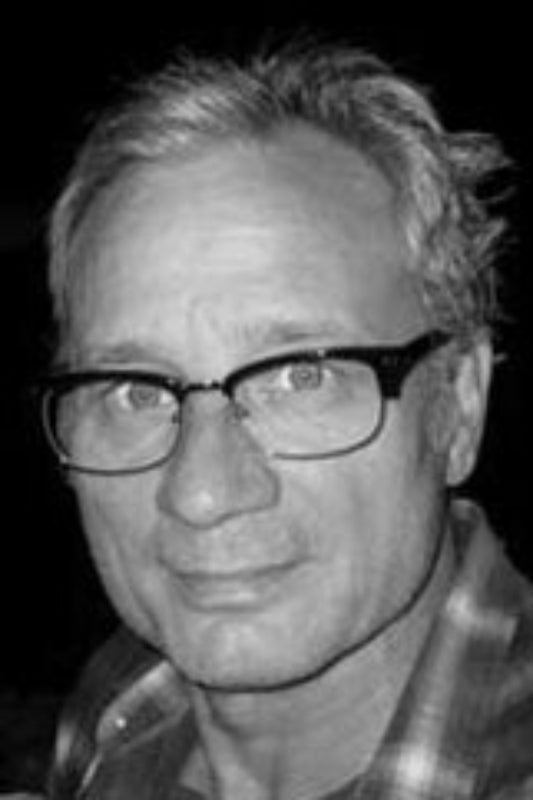 Close-up of a person wearing glasses with a neutral expression