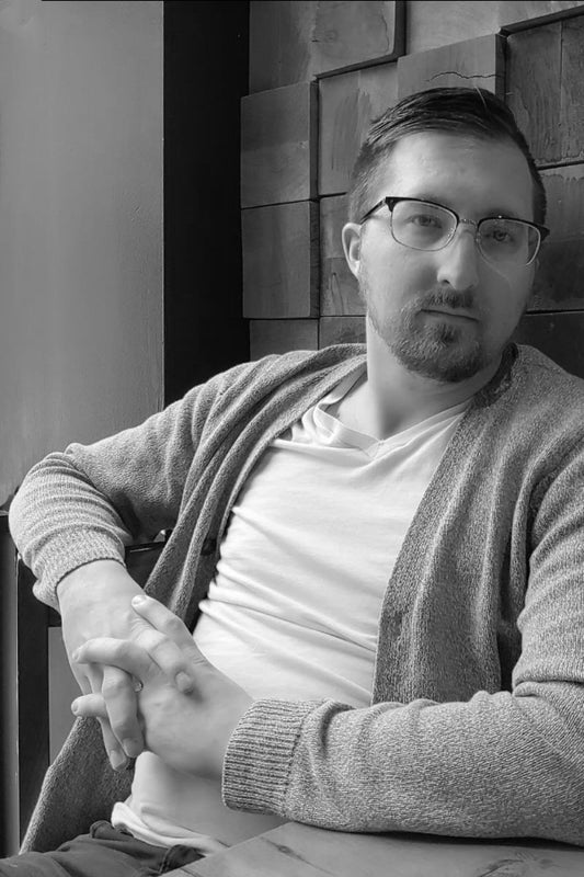 Black and white photo of a man wearing glasses and a sweater.