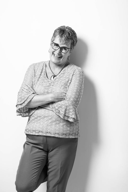 Person wearing glasses and a patterned shirt against a white background