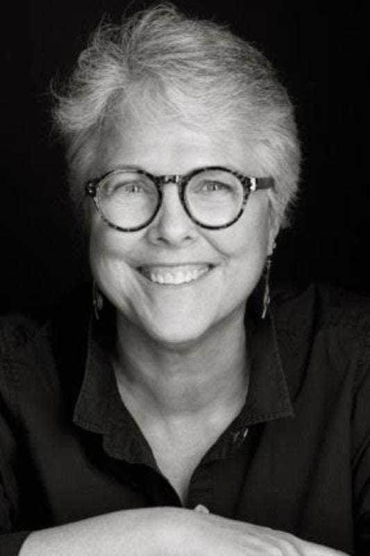 Black and white portrait of a person wearing glasses and a black shirt.