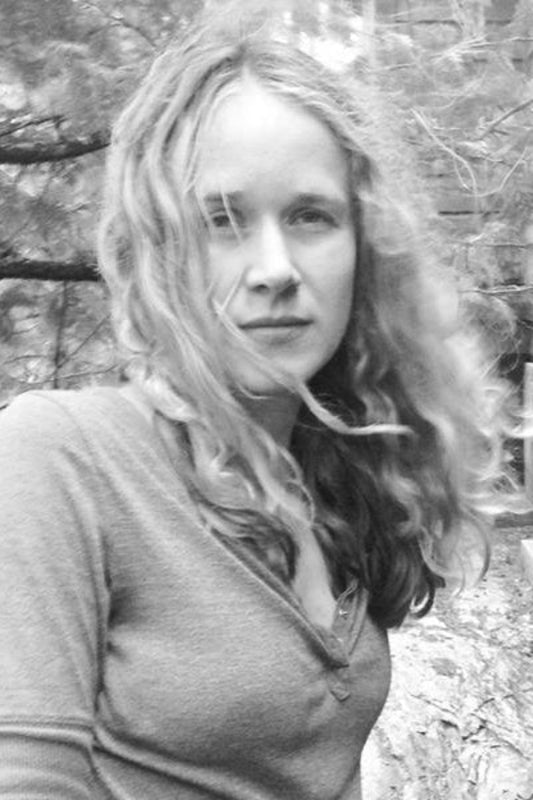 Person with long hair standing in a forest