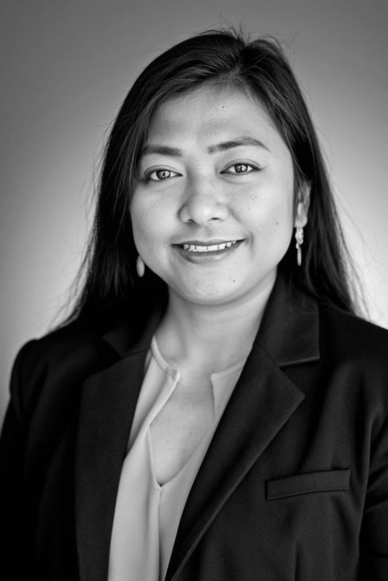 Black and white portrait of a Saren Keang wearing a dark blazer.