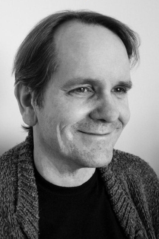 Black and white portrait of a man with a neutral expression.