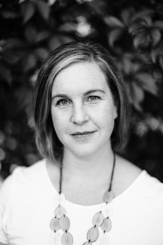 Black and white portrait of a woman with short hair against a blurred natural background
