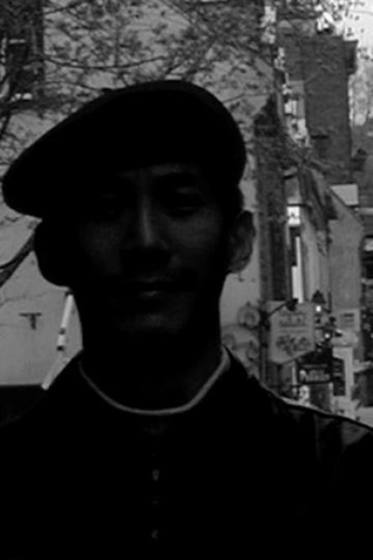 Person wearing a beret with a blurred urban background