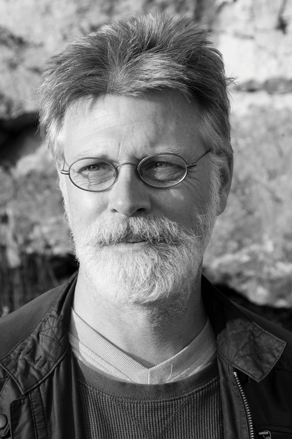 Black and white portrait of a man with glasses and a beard.