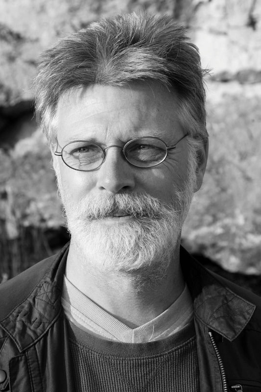 Black and white portrait of a man with glasses and a beard.