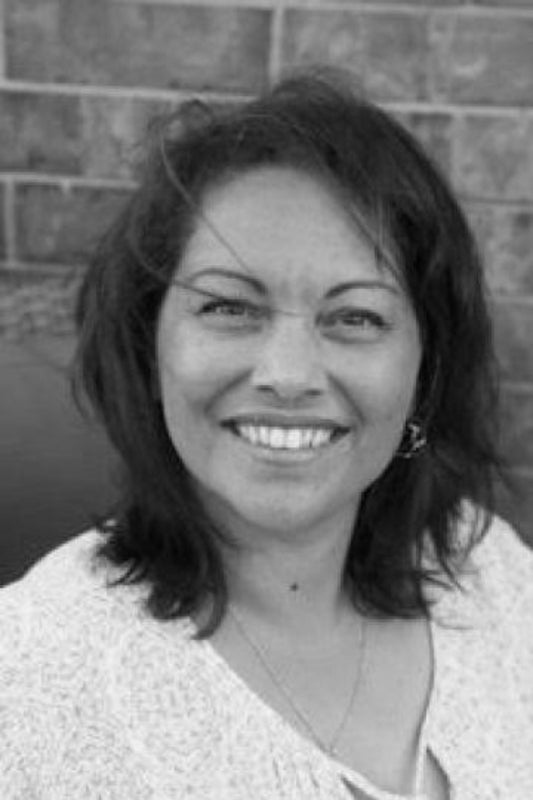Black and white photo of a woman with a brick wall background
