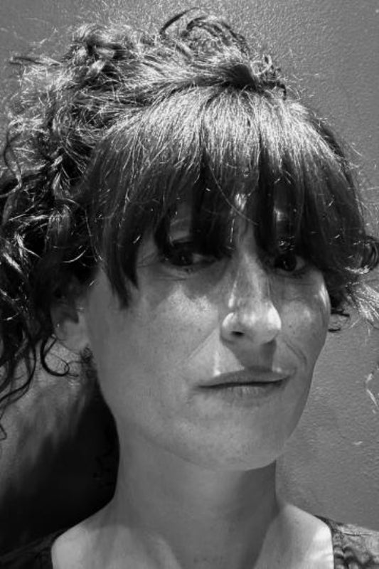 Black and white portrait of a person with textured hair against a neutral background