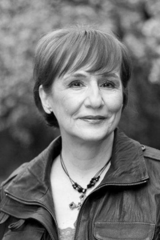 Black and white portrait of a woman with short hair, wearing a jacket and necklace.