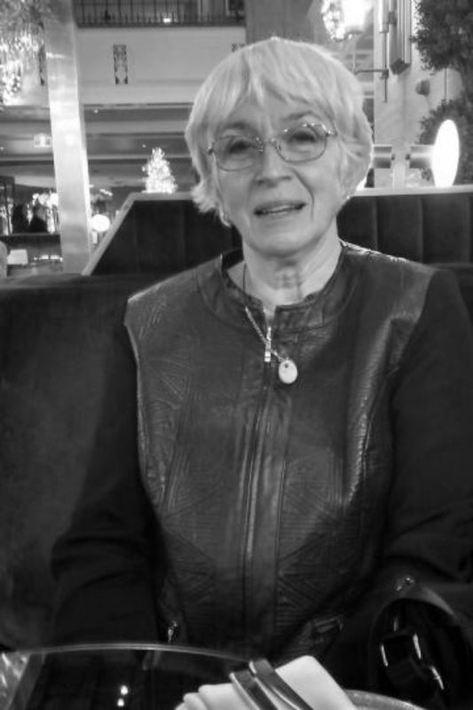 Person wearing a leather jacket sitting in a chair with a blurred background
