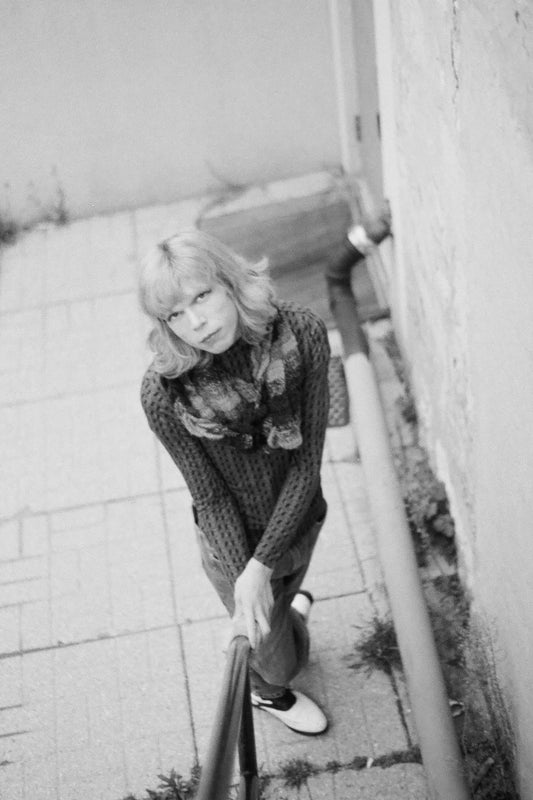 Person sitting on a step with a reflective surface below